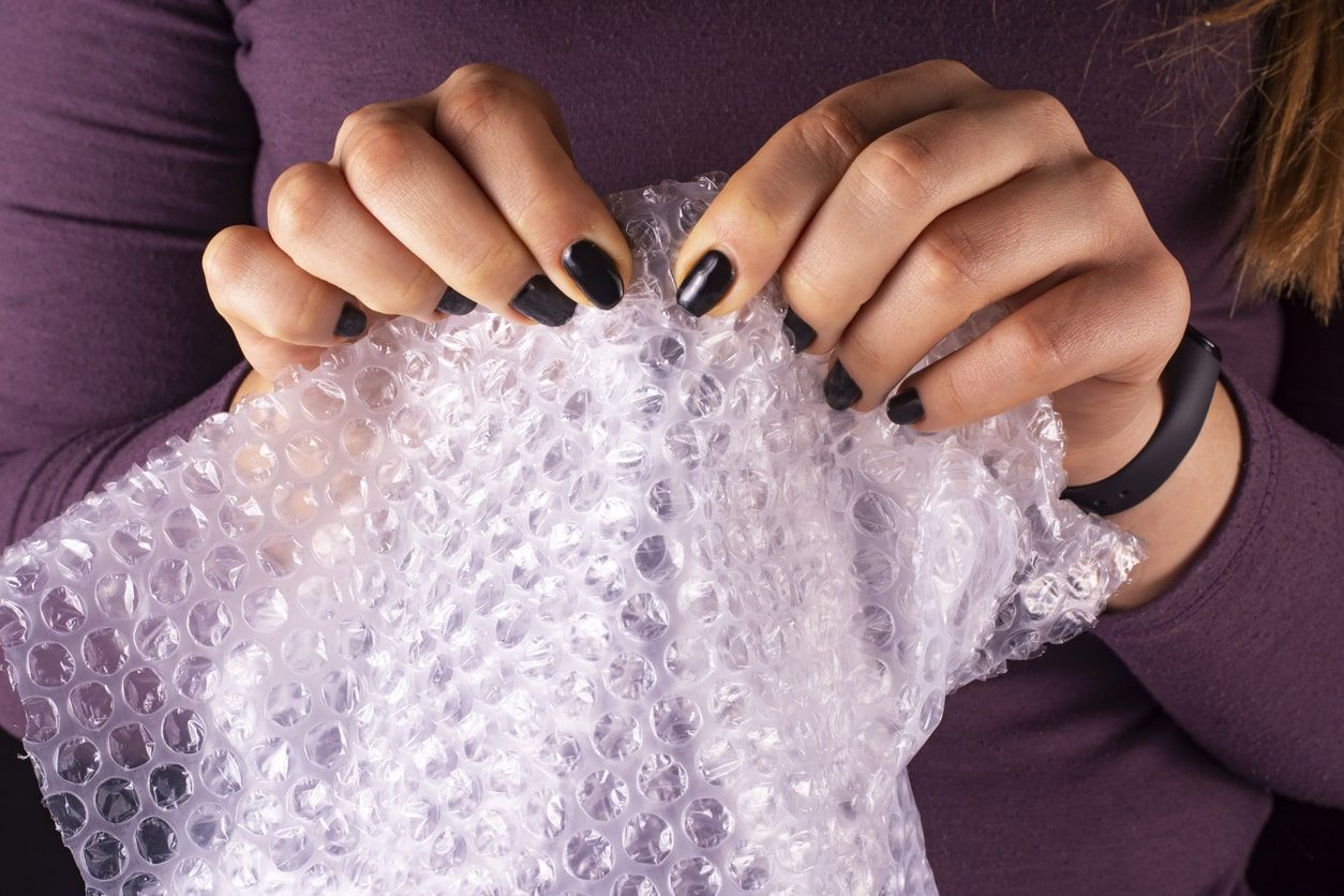 woman popping bubble wrap - نایلون حبابدار